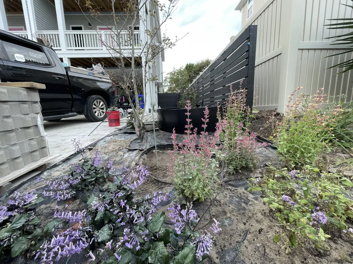 Layered flowering plants in a finished side-yard garden bed