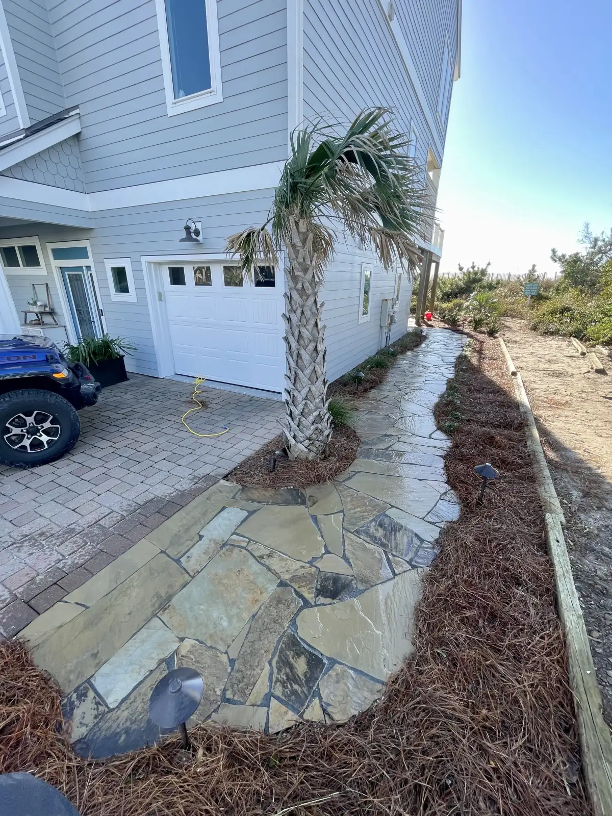 Stone retaining wall with terraced planting beds on a coastal NC property