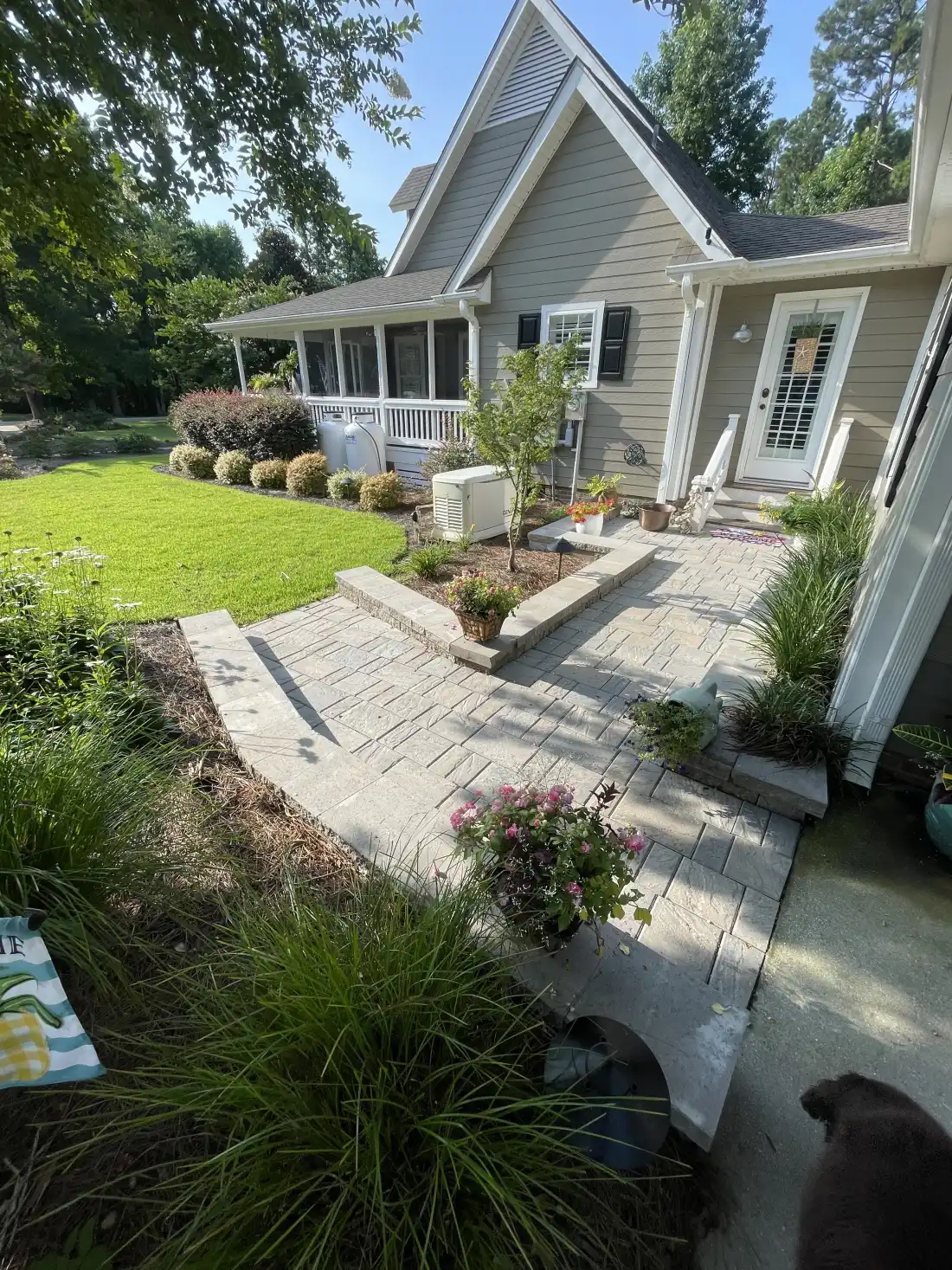 Finished paver walkway and raised planting beds beside a landscaped North Carolina home