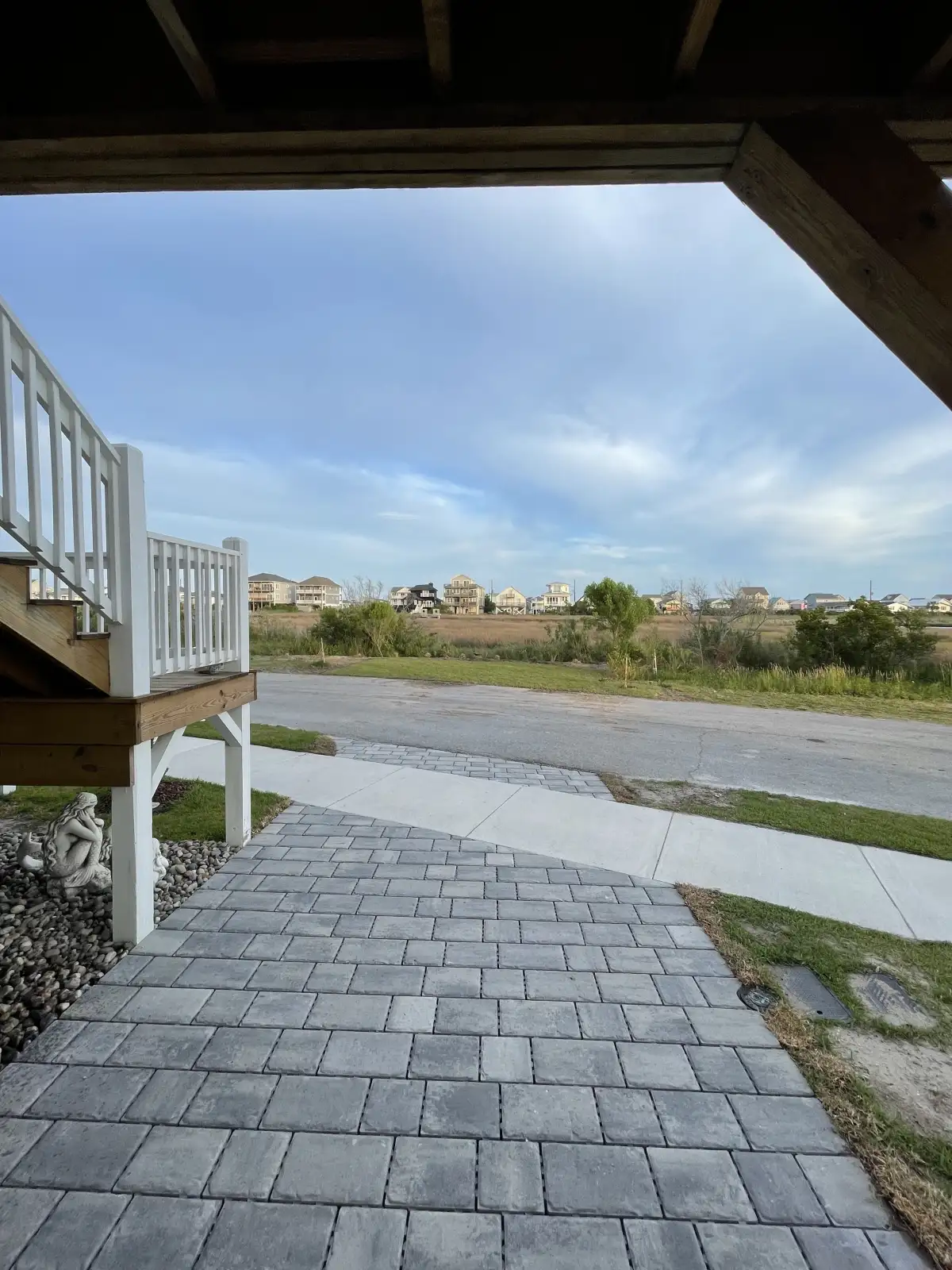 Finished paver surface beneath a raised coastal home overlooking the marsh