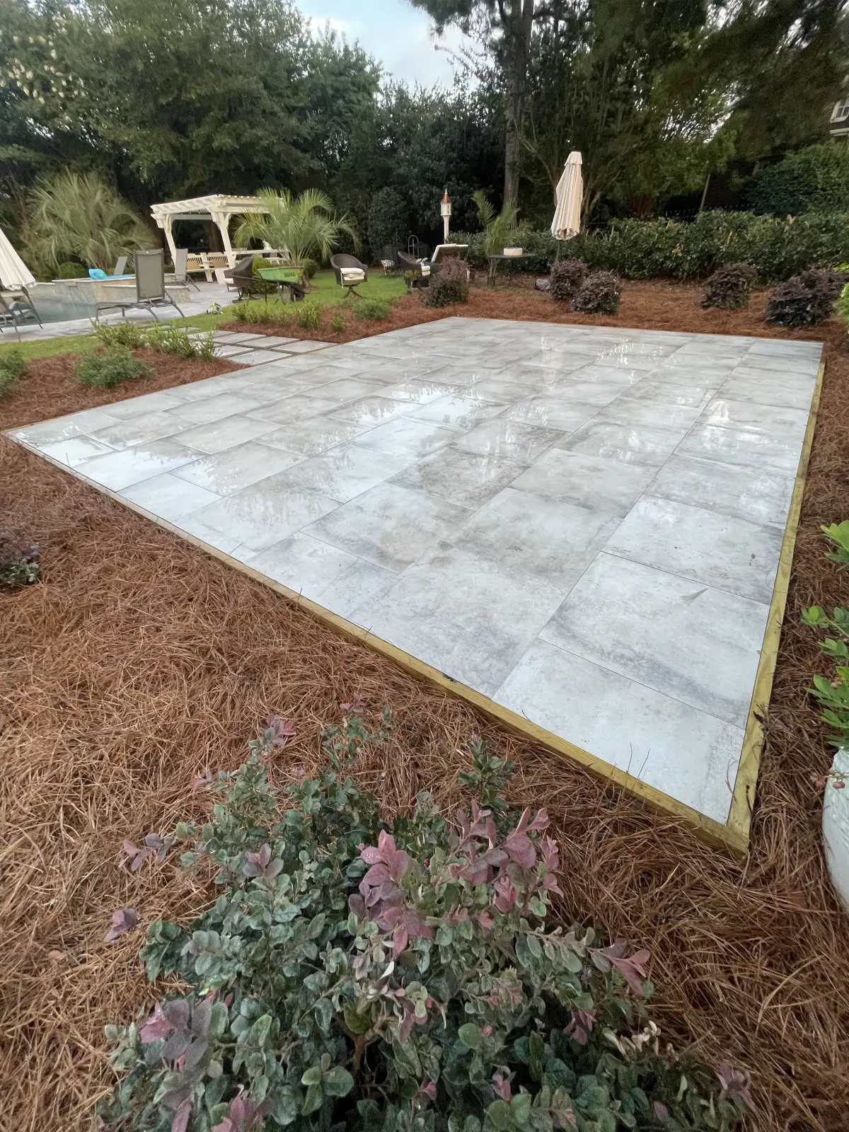Patio bordered by planted beds at an ENC Designs project